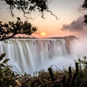 C’est le paysage phare à visiter au Zimbabwe et c’est ici que vous risquez de croiser le plus de touristes. Situées à la frontière avec la Zambie, un pont permet de passer d’un pays à l’autre.
Les chutes forment un mur d’1,7 km où le fleuve Zambèze se jette dans un canyon de 100 mètres de profondeur dans un bruit fracassant. Le site offre la possibilité de se balader sur les hauteurs des chutes et le long du Zambèze.
C’est une occasion unique pour observer la richesse de la faune et la beauté du paysage.
Une boucle dans la forêt humide est vivement recommandée pour apprécier la variété de la biodiversité de la région.
A noter que les hautes eaux ont lieu en mars-avril, c’est à cette période que vous pourrez assister au phénomène de brouillard d’eau et aux arcs-en-ciel.